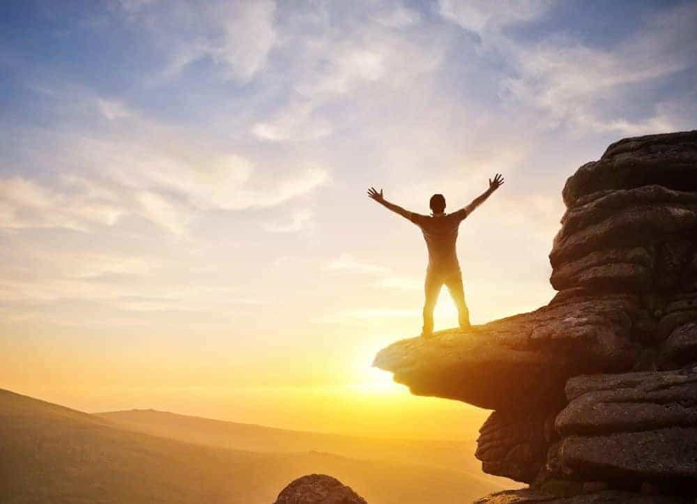 Person standing on the top of a mountain