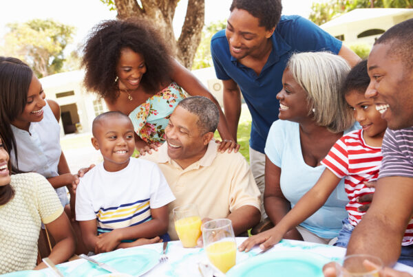 A group of people sitting around a table in a garden.