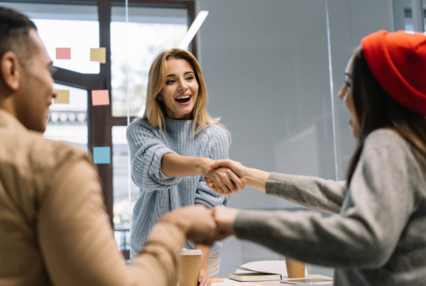 A group of people shaking hands in an office.